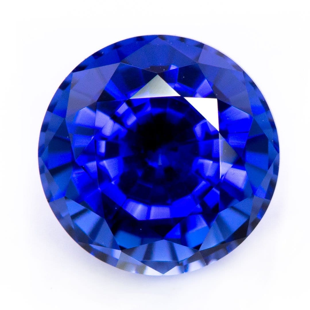 Round brilliant cut blue sapphire gemstone shown for color comparison